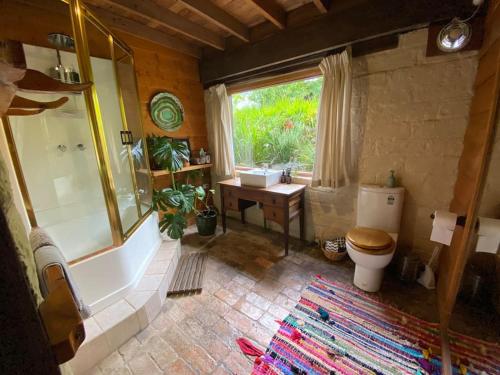 a bathroom with a tub and a toilet and a sink at Summer Paradise at the Valley Farm House in Healesville