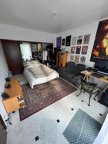 une chambre avec un lit, un canapé et un bureau dans l'établissement Magnifique maison + jardin à Paris Porte des Lilas, à Bagnolet