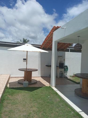 a patio with a table and an umbrella at Casa Arembepe in Camaçari