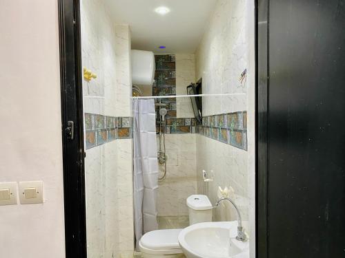 a bathroom with a shower and a toilet and a sink at 2 ch • WiFi • 5min de la gare TER in Dakar