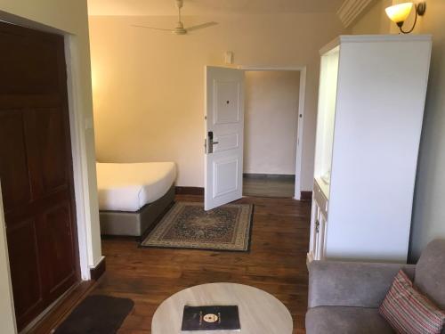 a small room with a bed and a couch at The Heritage Club - Tripura Castle Hotel and Spa in Shillong