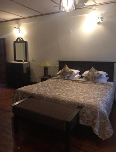 a bedroom with a bed with a table and a television at The Heritage Club - Tripura Castle Hotel and Spa in Shillong