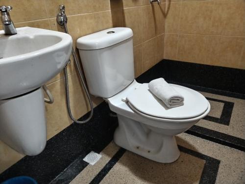 a bathroom with a white toilet and a sink at Maple Boutique Hotel Kota Bharu in Kota Bharu