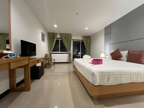 Zephyr Grand Hotel في شاطيء باتونغ: غرفة نوم بسرير ومكتب وتلفزيون