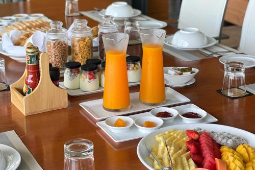 een tafel met borden eten en twee glazen sinaasappelsap bij Villa Blue View in Mae Nam