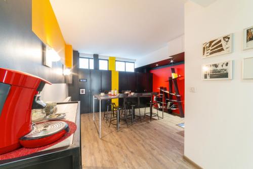 une salle à manger avec un mur rouge et jaune dans l'établissement Maison Mondrian, à Mulhouse