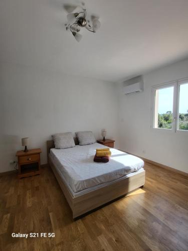 Habitación blanca con cama y ventana en Maison Confort et détente, en Tavaco