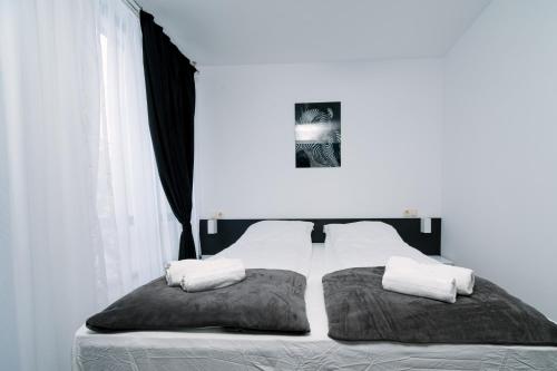 a bedroom with a bed with two pillows on it at PANORAMA SPA ASPEN APARTMENT in Razlog