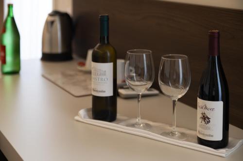 two bottles of wine and two glasses on a counter at Palazzo Cappuccini Art Relais in Naples
