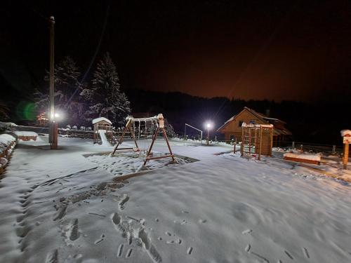 an empty playground in the snow at night at Chata U dědka in Prostřední Bečva