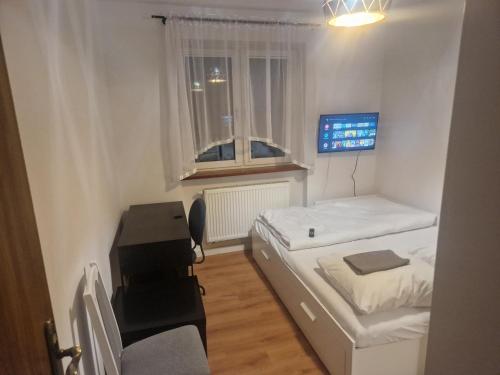 a small room with two beds and a desk at Noclegi Budomas Budget Wrocław-Szymanów FreeParking SmartTv in Wrocław