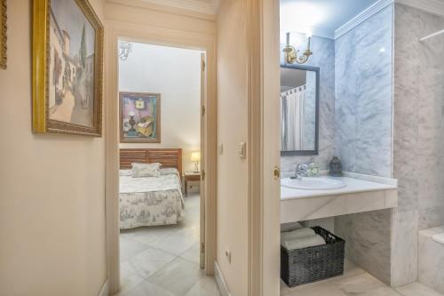 baño con lavabo, espejo y cama en Palacio Marqués Vega Armijo & Parking incluido, en Córdoba