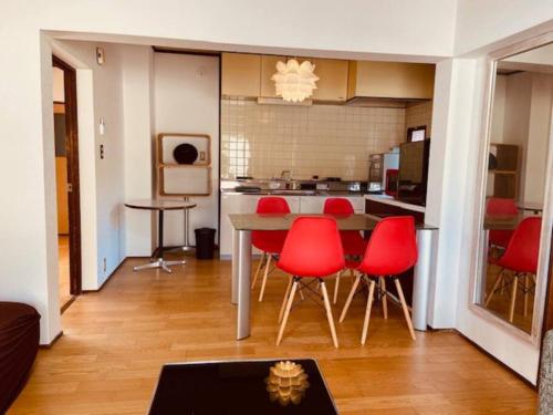 a kitchen with red chairs and a table in a room at sonic apartment annex 201 4名様まで同一価格 in Dazaifu