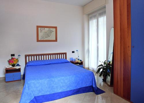a bedroom with a blue bed and a window at Residenza Adelaide 2 in Finale Ligure