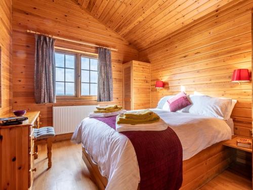a bedroom with two beds in a wooden cabin at 2 Bed in Clovelly 00362 in Clovelly