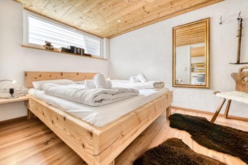 um quarto com uma cama grande e lençóis brancos em Ferienwohnung Zweisamkeit em Brand