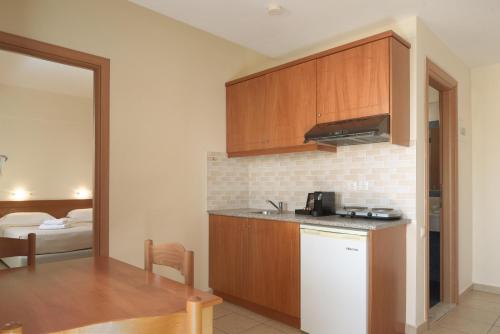 a kitchen with a white refrigerator and a table at Asterias Village in Hersonissos