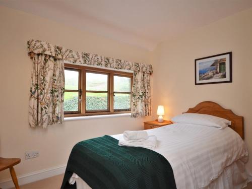 a bedroom with a bed and a window at 3 Bed in Wembury COMBV in Wembury