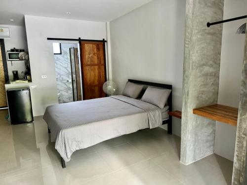 喀比的住宿－aonangstudio，一间白色客房内的床铺卧室