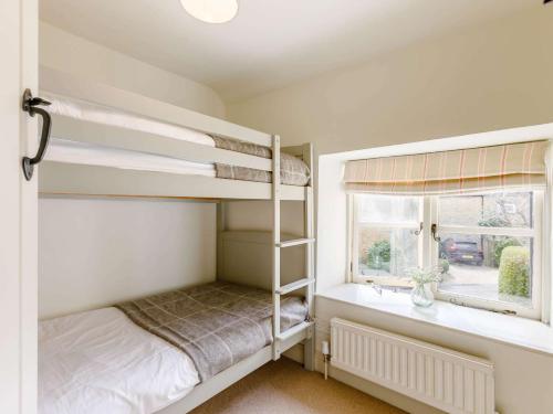 a bedroom with two bunk beds and a window at 2 Bed in Bourton-on-the-Water 28292 in Bourton on the Water