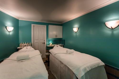 two beds in a room with blue walls at Dalhousie Castle Hotel in Bonnyrigg