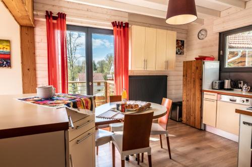 a kitchen and dining room with a table and chairs at Le refuge du peintre in Gérardmer