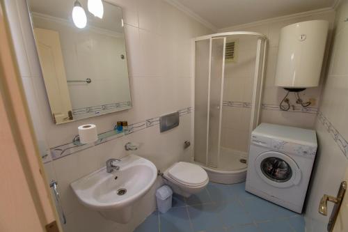ein Badezimmer mit einem Waschbecken und einer Waschmaschine in der Unterkunft Sunset Beach Club Aqualettings Oyster 5 in Fethiye