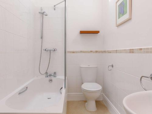 a white bathroom with a toilet and a sink at 3 Bed in Praa Sands 36259 in Germoe