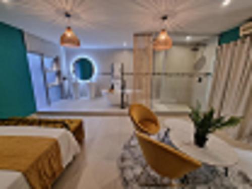 um quarto com uma cama, uma mesa e uma banheira em Club Cocomo em Hartbeespoort