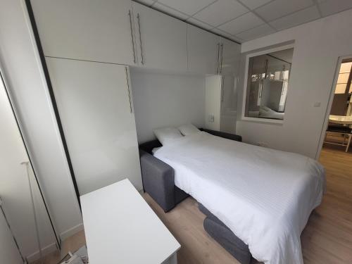 une petite chambre avec un lit et une table dans l'établissement Studio bien équipé au calme à Montmartre, à Paris