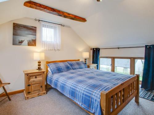 um quarto com uma cama com um edredão azul em 2 Bed in South Molton 88992 em Bishops Nympton