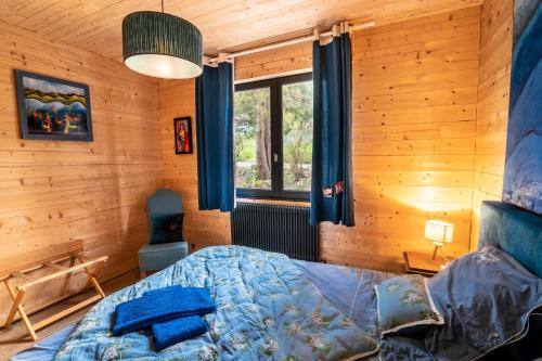une chambre avec un lit dans une pièce en bois dans l'établissement Le refuge du peintre, à Gérardmer