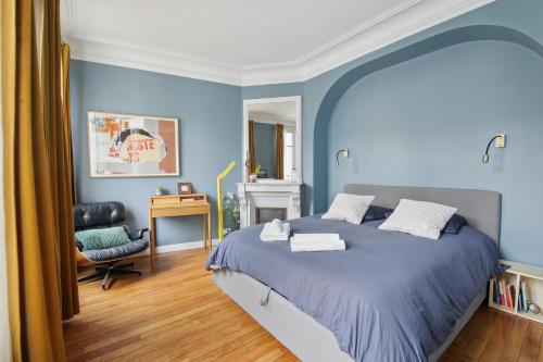 - une chambre bleue avec un lit et une chaise dans l'établissement Appartement Familial 7 personnes -Entre Opéra et Montmartre by Weekome, à Paris