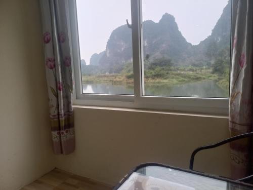 a window with a view of a river and mountains at Trang An Pristine View homestay in Ninh Binh
