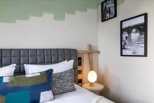 a bedroom with a bed with a headboard and a lamp at Les Artistes in Paris