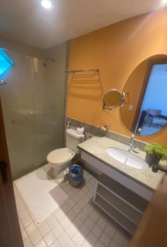 a bathroom with a toilet and a sink and a mirror at Marulhos Resort Flat E205 in Porto De Galinhas
