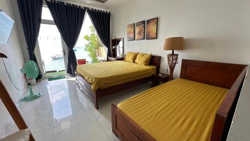 a bedroom with two beds and a window at sunset beach house in Phu Quoc