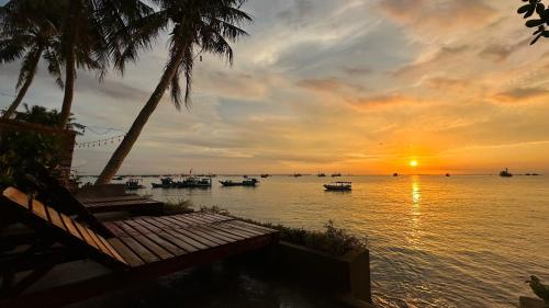 zachód słońca nad wodą z łodziami w obiekcie sunset beach house w Duong Dong