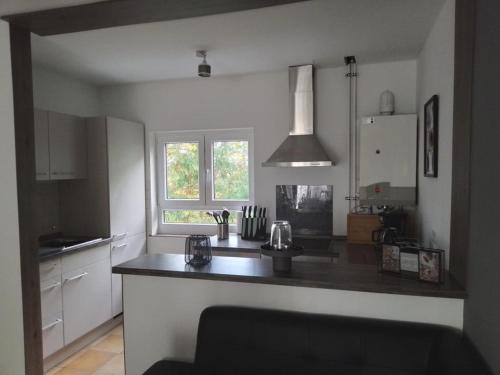 a kitchen with a black counter top in a room at NEU! Moderne Ferienwohnung am Teufelsstein in Patersberg