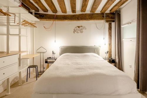 une chambre avec un grand lit blanc dans une pièce dans l'établissement Appartement cosy proche Beaubourg, à Paris