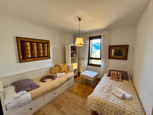 a bedroom with two beds and a chair and a window at C15 - Apartamento gran terraza Aigualluts - Villmor in Cerler