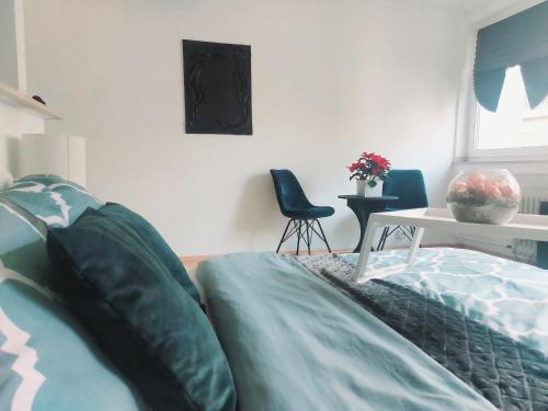 a bedroom with a bed and a table and a chair at Central and calm appartement in Aachen in Aachen