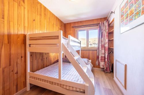 une chambre avec deux lits superposés dans une pièce aux murs en bois dans l'établissement Le Goléon - pistes accessibles à pied, à La Toussuire