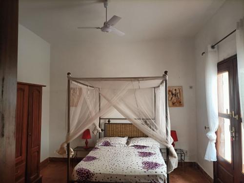 sypialnia z łóżkiem z baldachimem w obiekcie La coolitude w mieście Toubab Dialaw