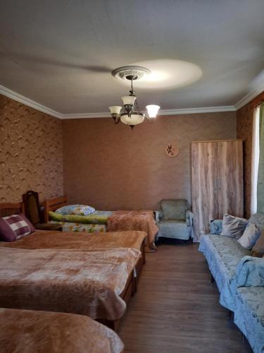 a bedroom with two beds and a couch at Family Hotel Maia - Cемейная гостиница Майя in Dashbashi