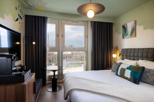 a bedroom with a bed and a tv and a window at Les Artistes in Paris