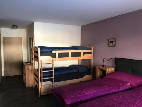 a bedroom with two bunk beds with purple sheets at Derby 25 in Arosa