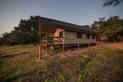 a tent with a black roof in a field at Nkambeni Safari Camp in Hazyview