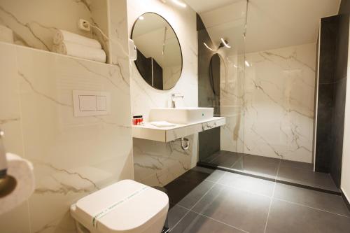La salle de bains est pourvue de toilettes, d'un lavabo et d'un miroir. dans l'établissement Axe Boutique, à Galaţi
