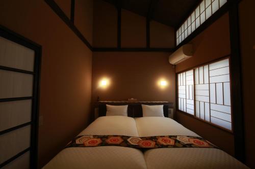 two beds in a small room with two windows at 松の峦 in Kyoto